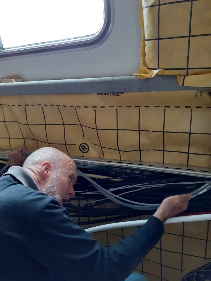 Herman legt de losse kabels in de goot van de slaapkamer