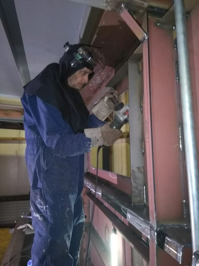 Frans met monnikskap en gelaatsbescherming slakken slijpen